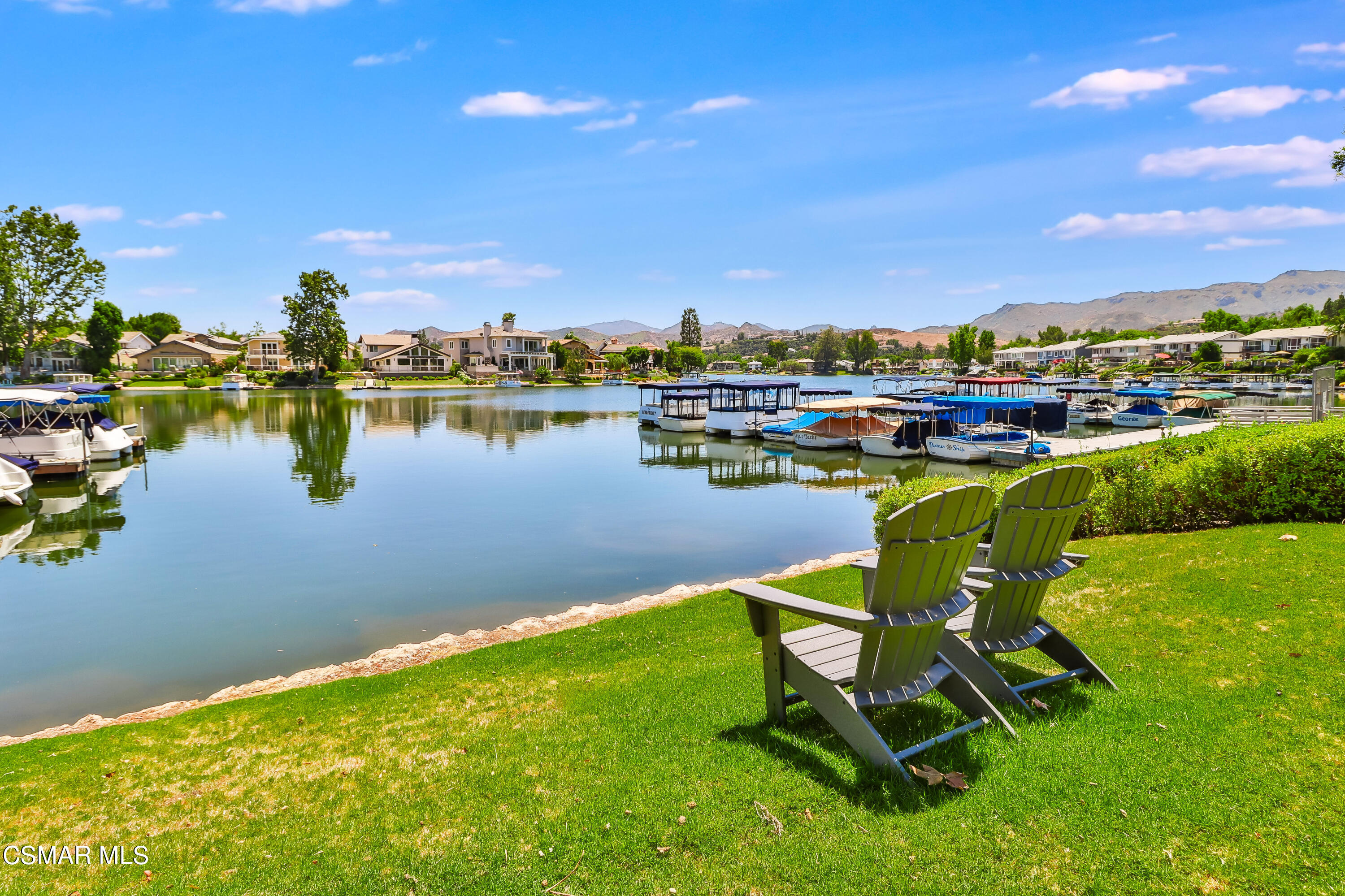 a view of a lake with lawn chairs