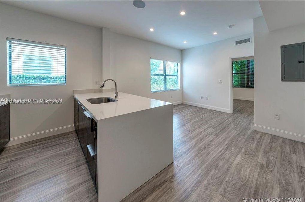 a kitchen with a wooden floor and window