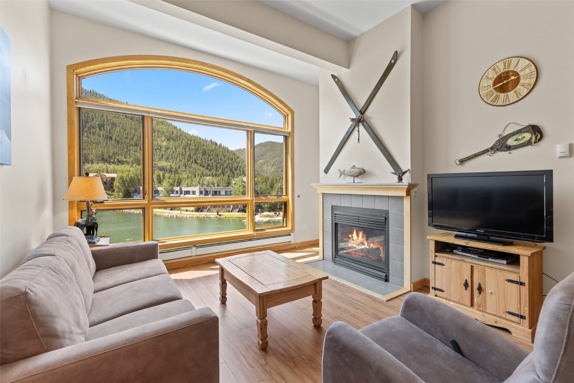 a living room with furniture a floor to ceiling window and a flat screen tv