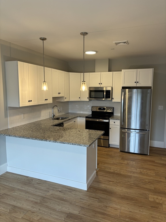 a kitchen with kitchen island granite countertop a sink a center island stainless steel appliances and cabinets