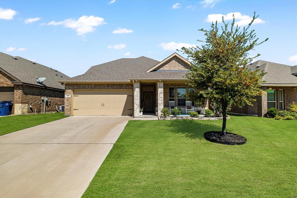 a front view of a house with plants and a yard