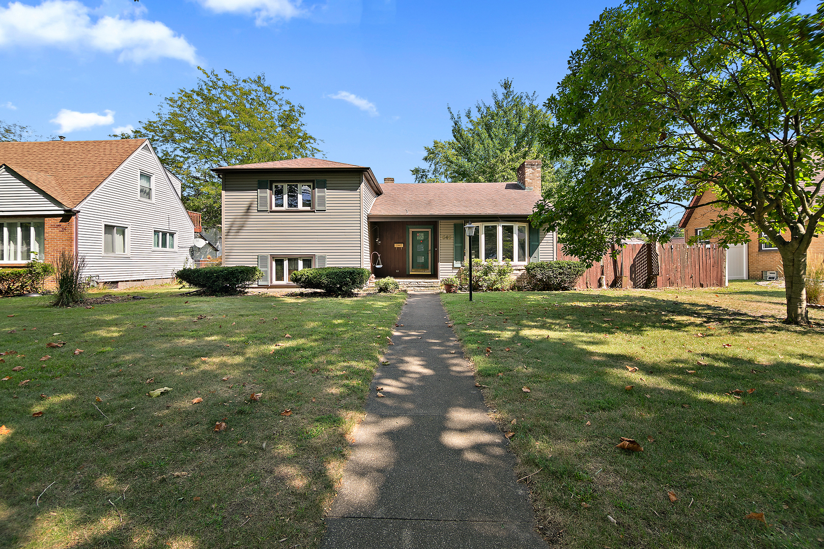 a front view of a house with a garden and trees