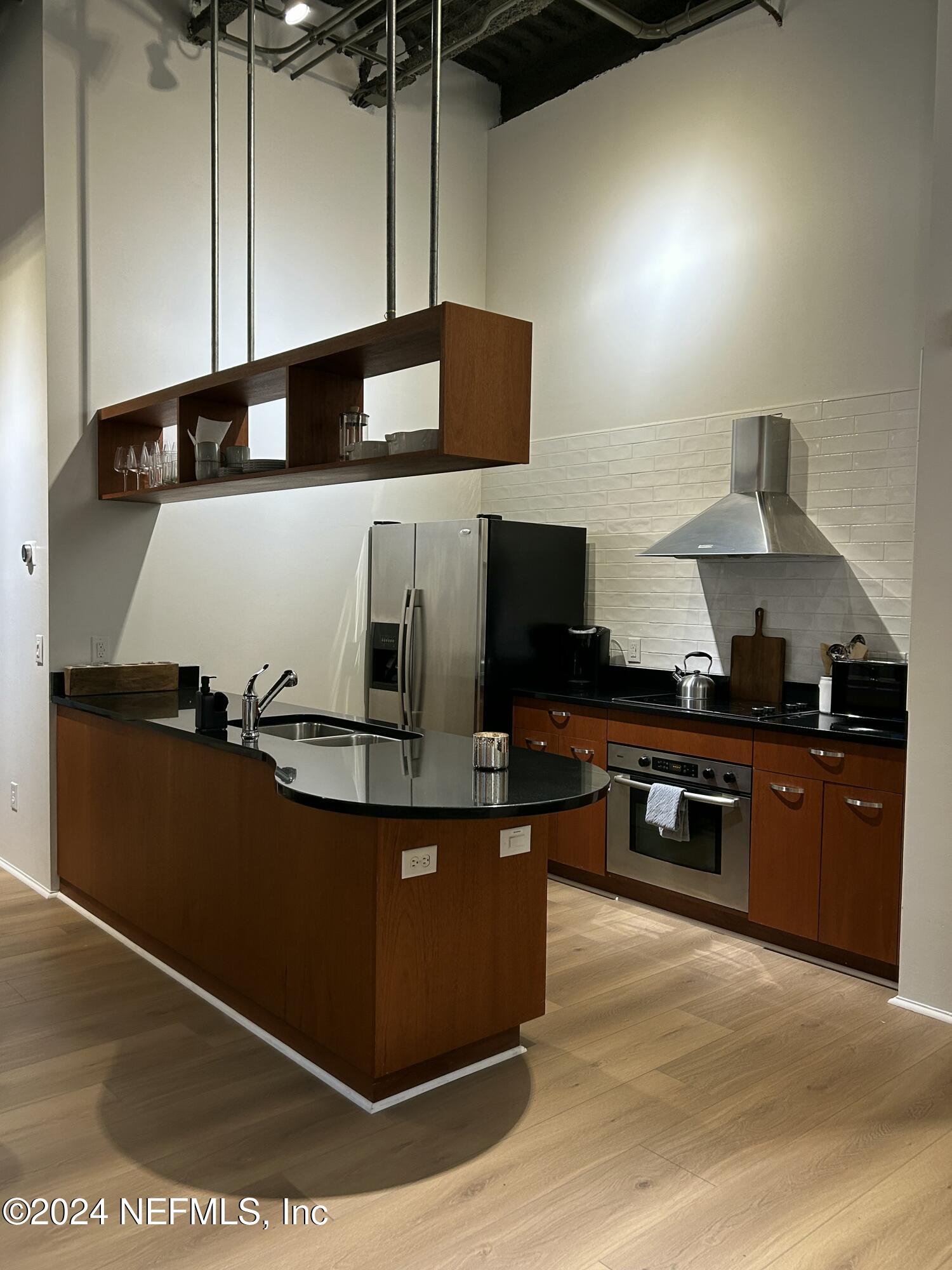 a kitchen with stainless steel appliances granite countertop a sink and a stove