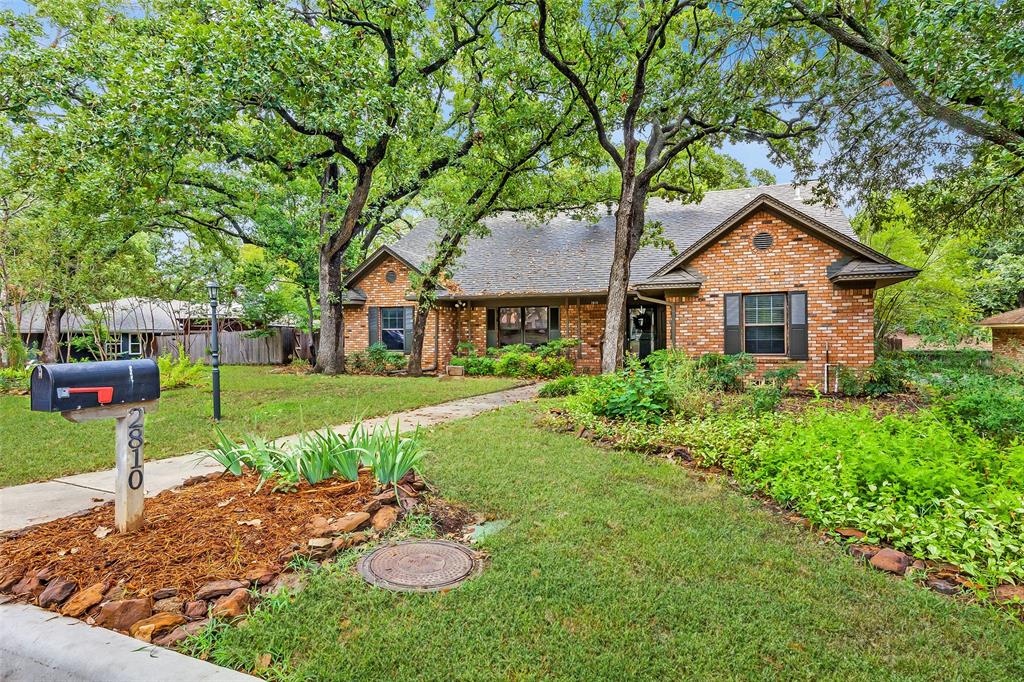 a front view of a house with a yard and trees