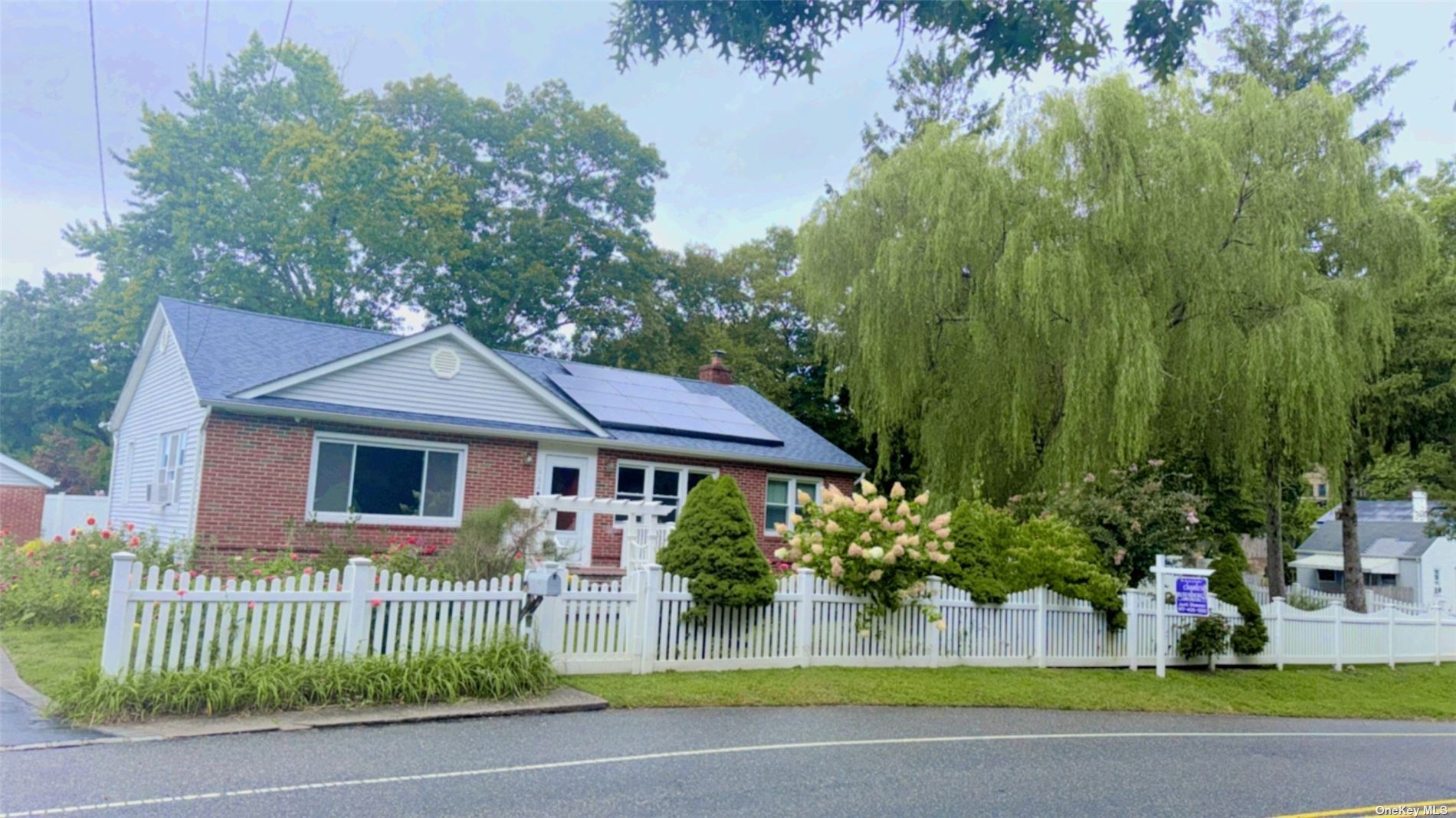 a front view of a house with a garden and plants