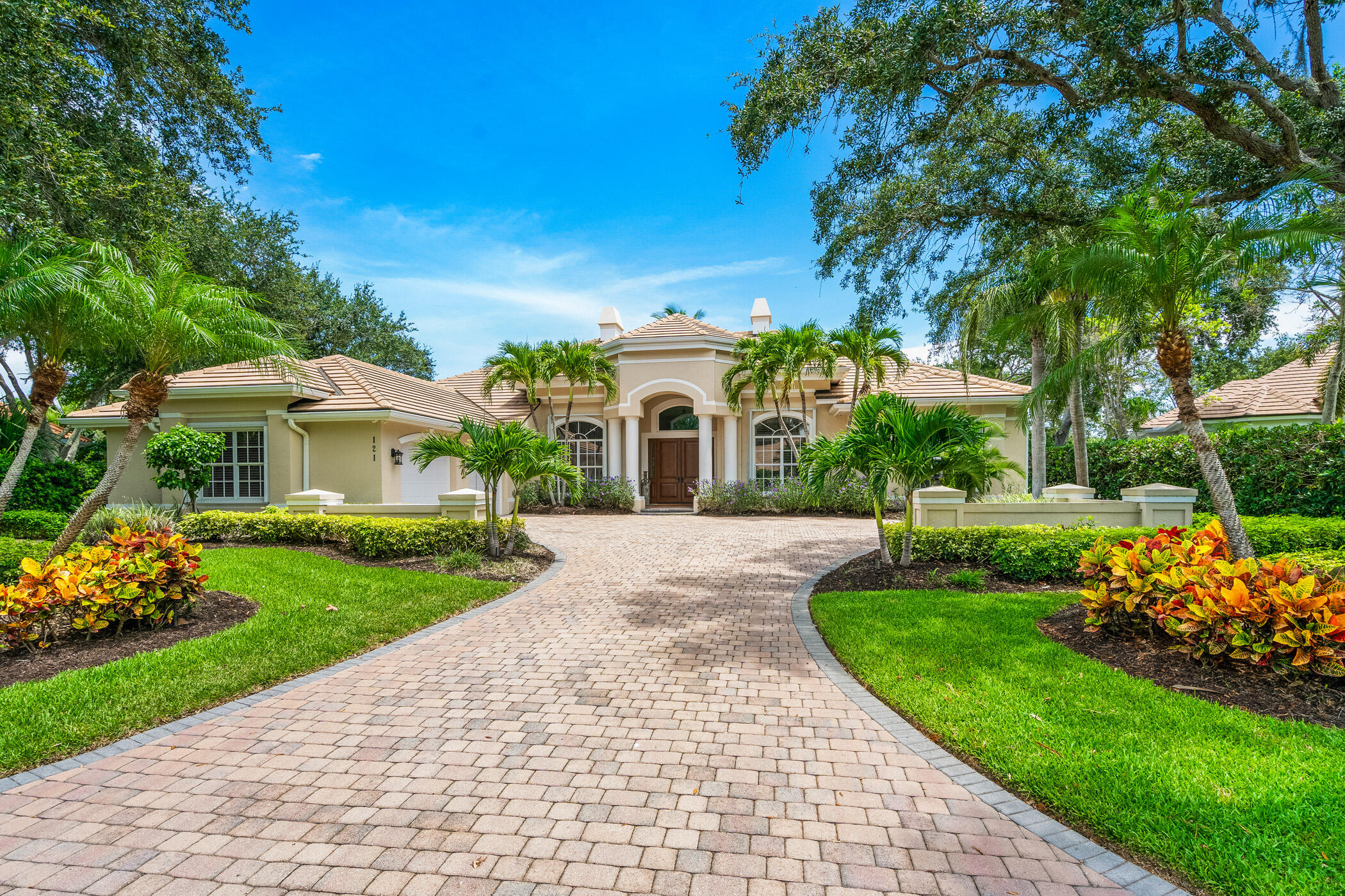 a white house with a big yard and potted plants