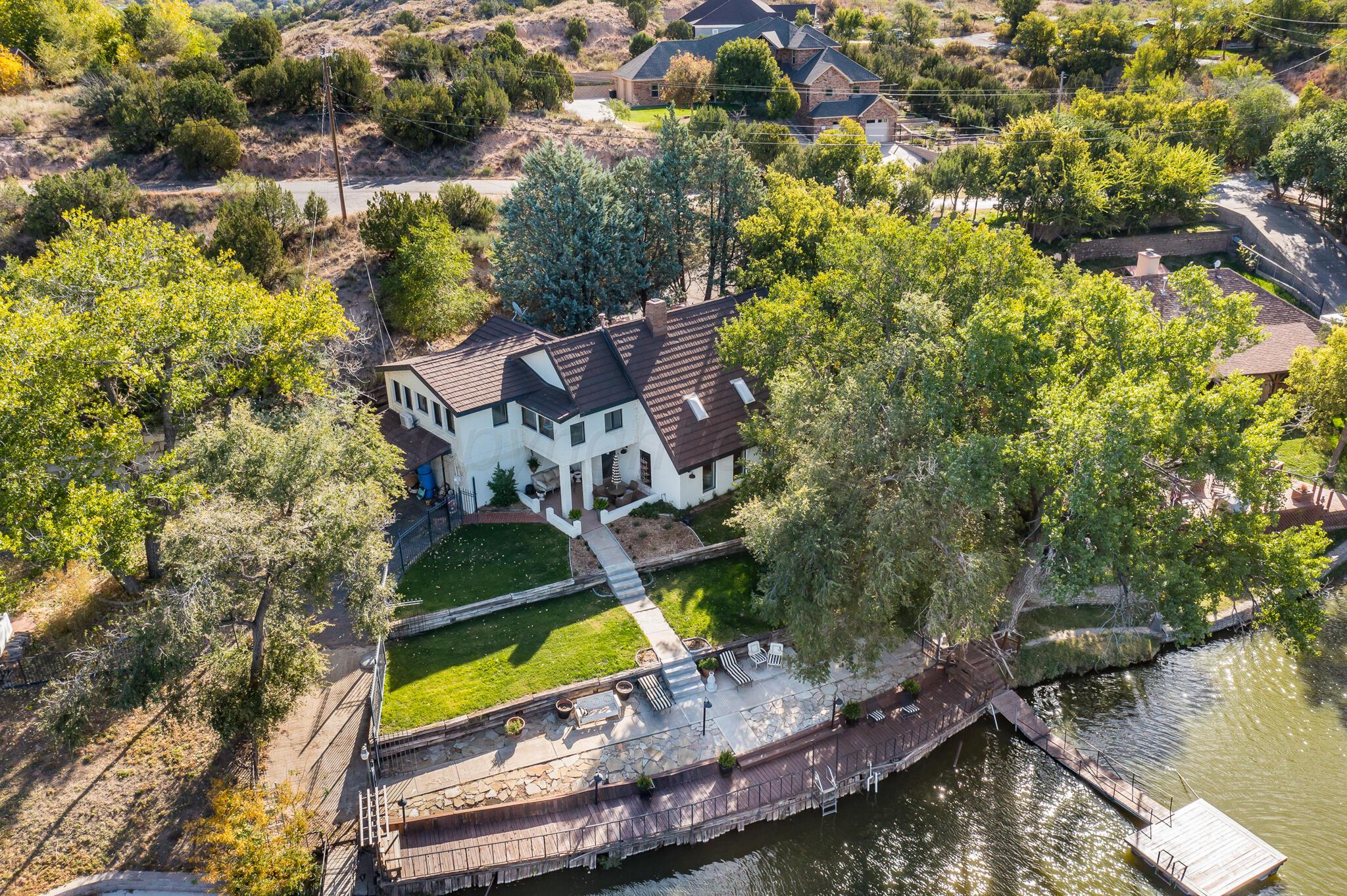 an aerial view of a house with a garden and lake view