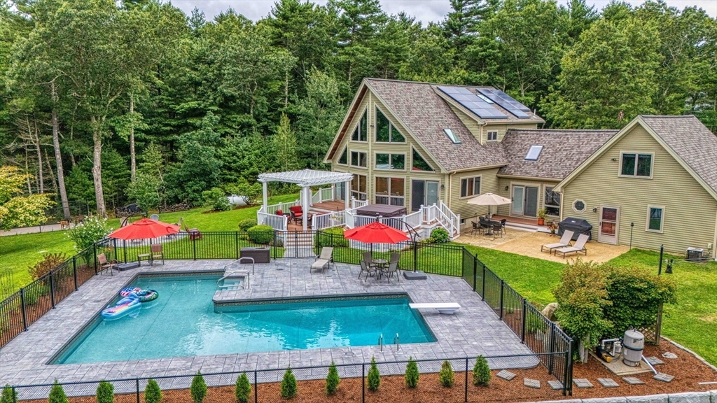 an aerial view of a house with swimming pool and patio