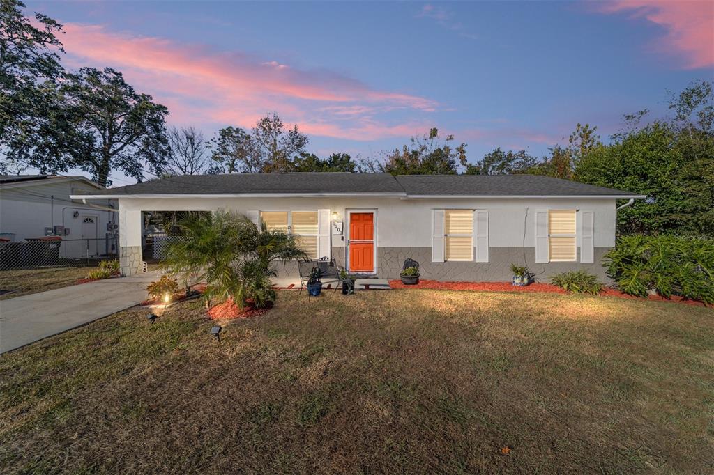 a view of a house with backyard and a patio