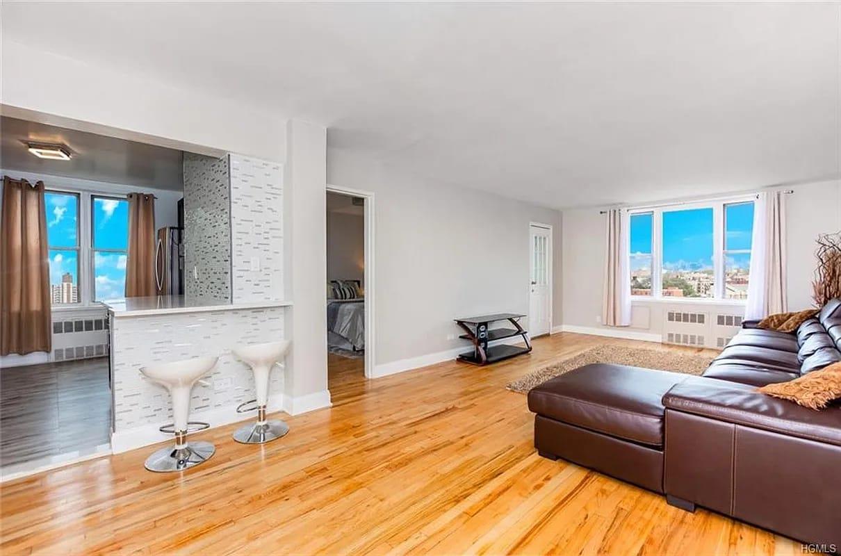 Living room with light wood-type flooring and radiator heating unit