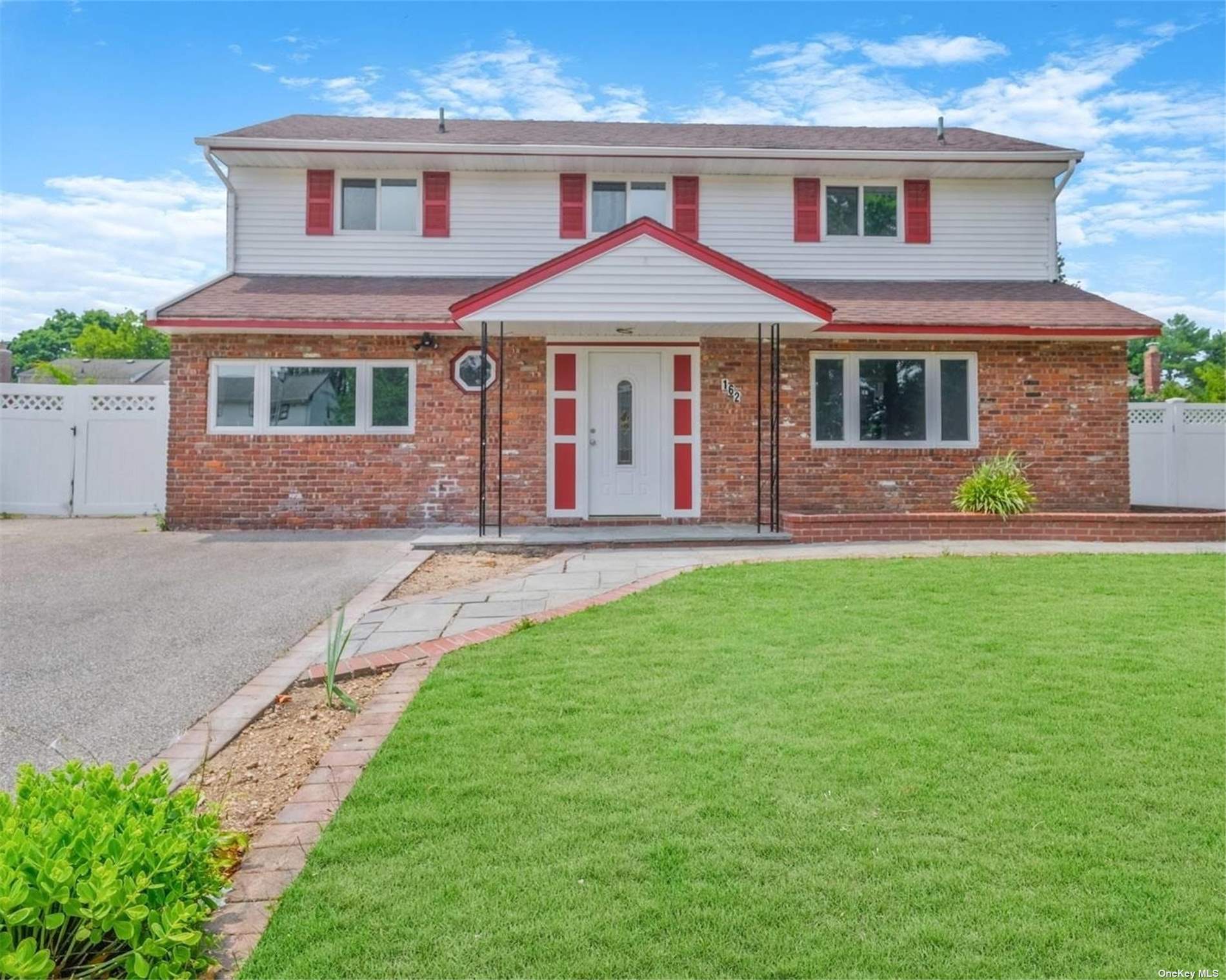 a front view of a house with a garden and yard