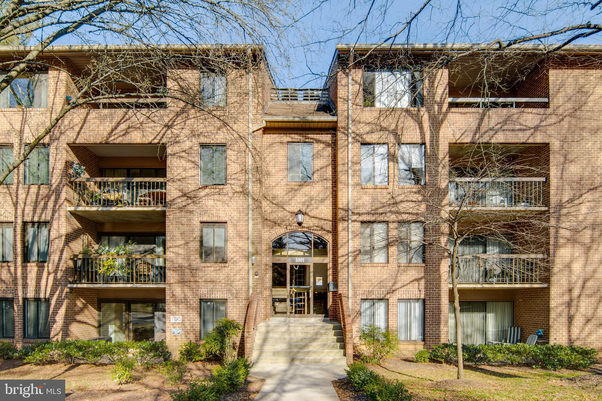 a front view of a building with streets and trees