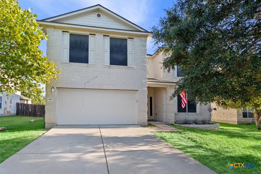 a front view of a house with a yard and garage