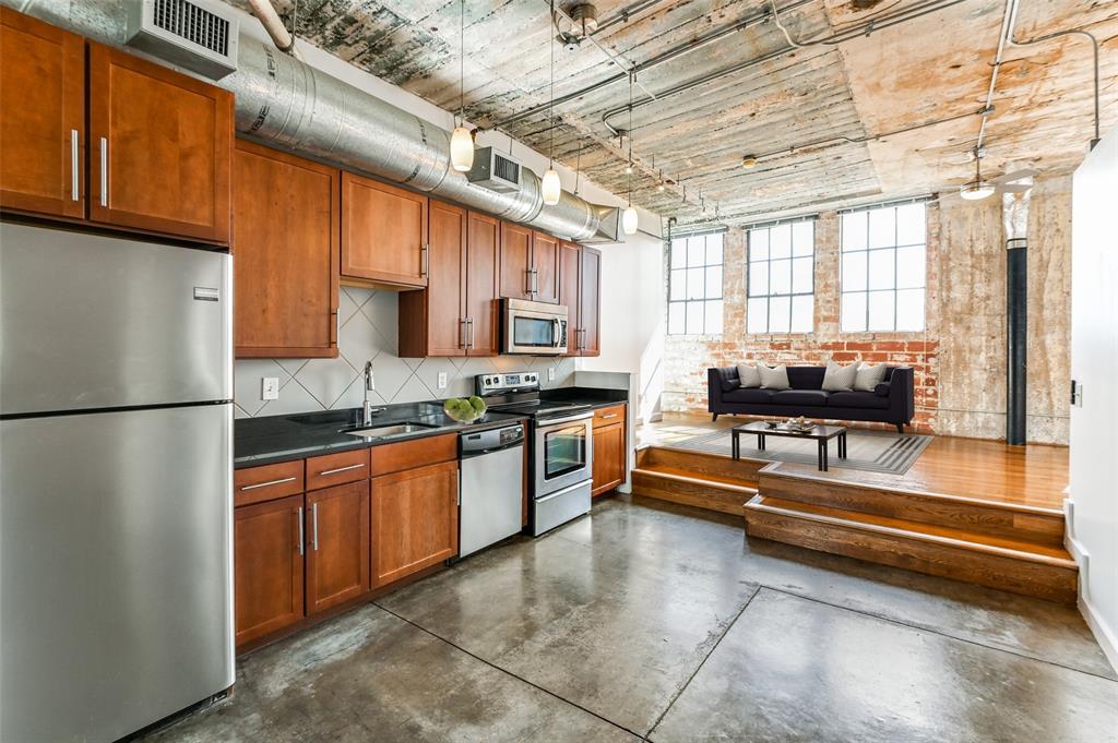 a kitchen with kitchen island granite countertop a sink stainless steel appliances and cabinets