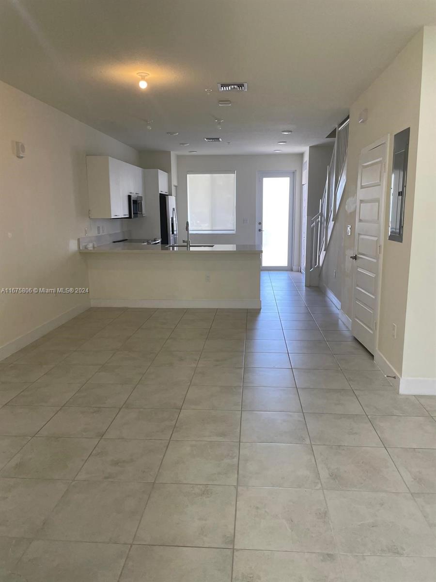 a view of a hallway with kitchen and granite countertop