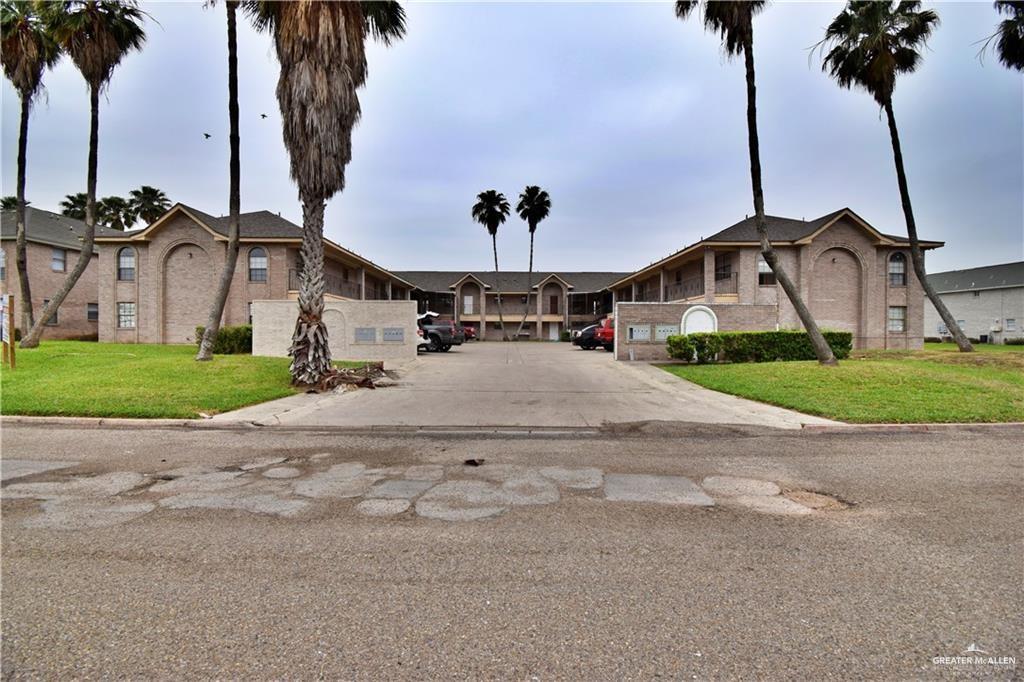 a view of a street with a building and a palm tree