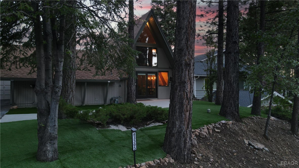 a view of a house with garden and trees