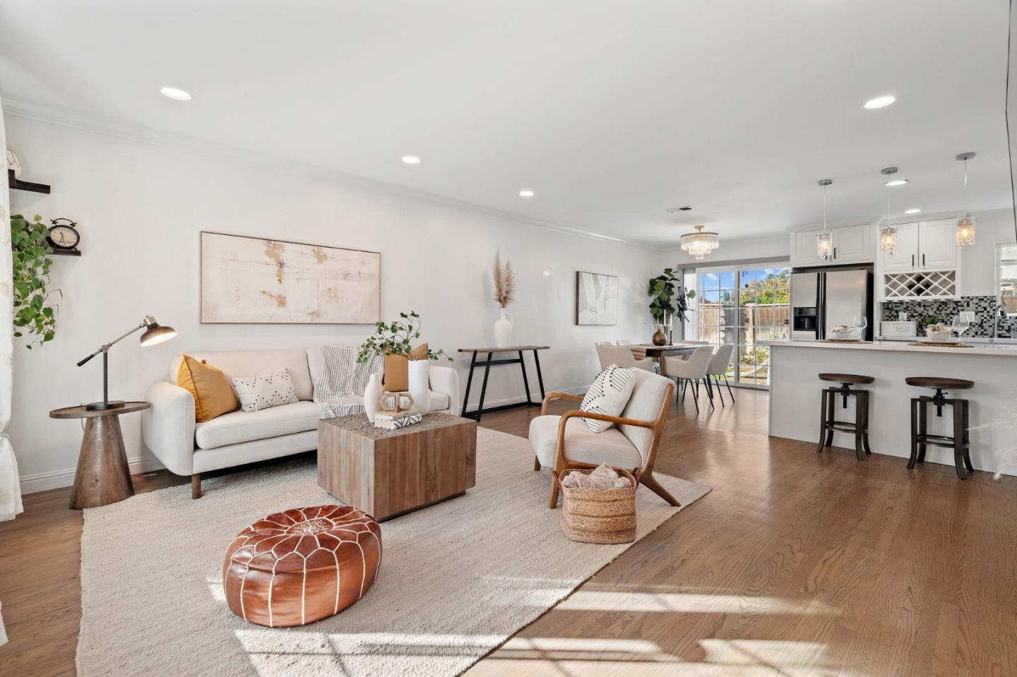 a living room with furniture a wooden floor and a kitchen