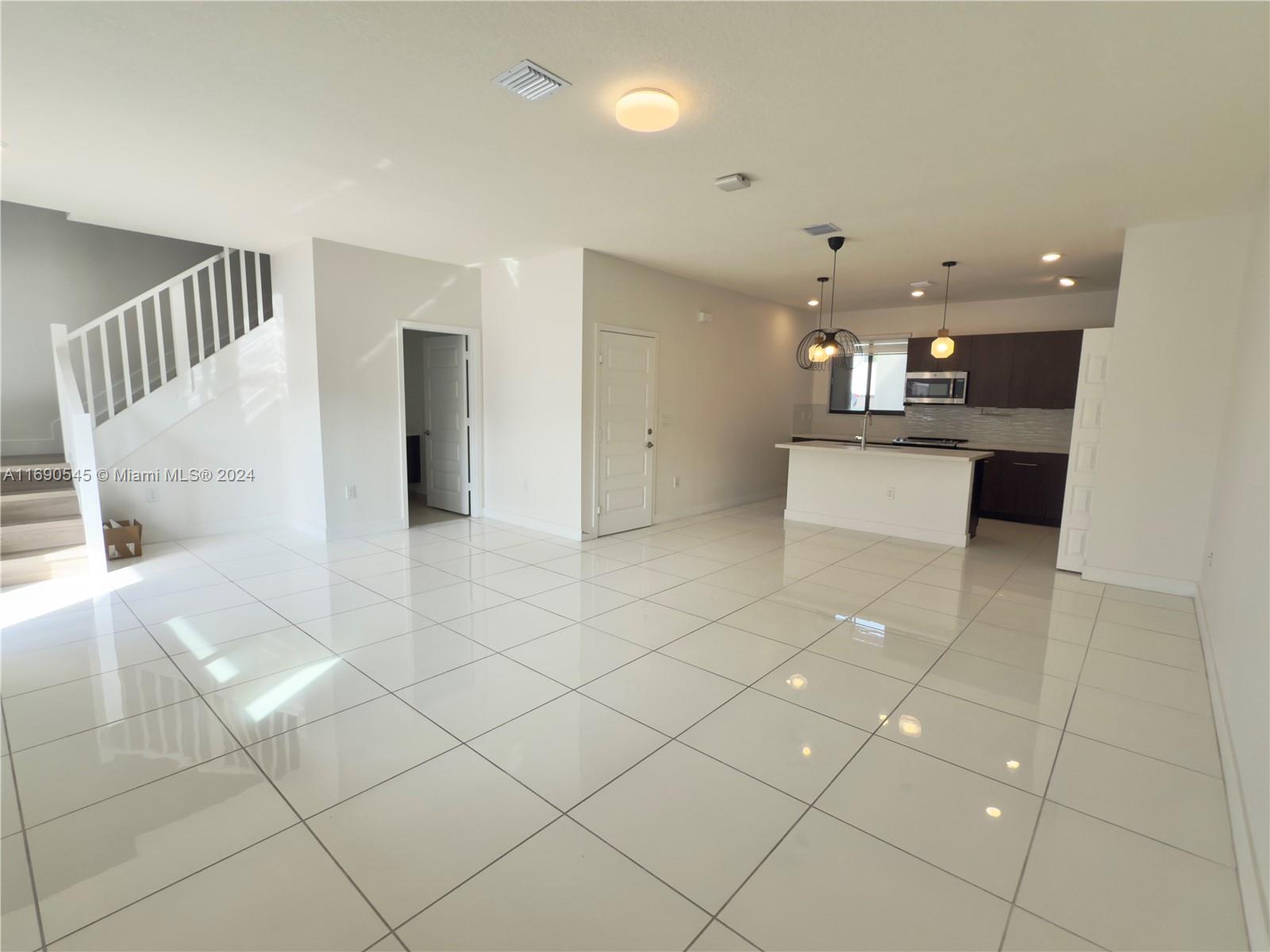 a view of a living room and kitchen with granite countertop a rug floor