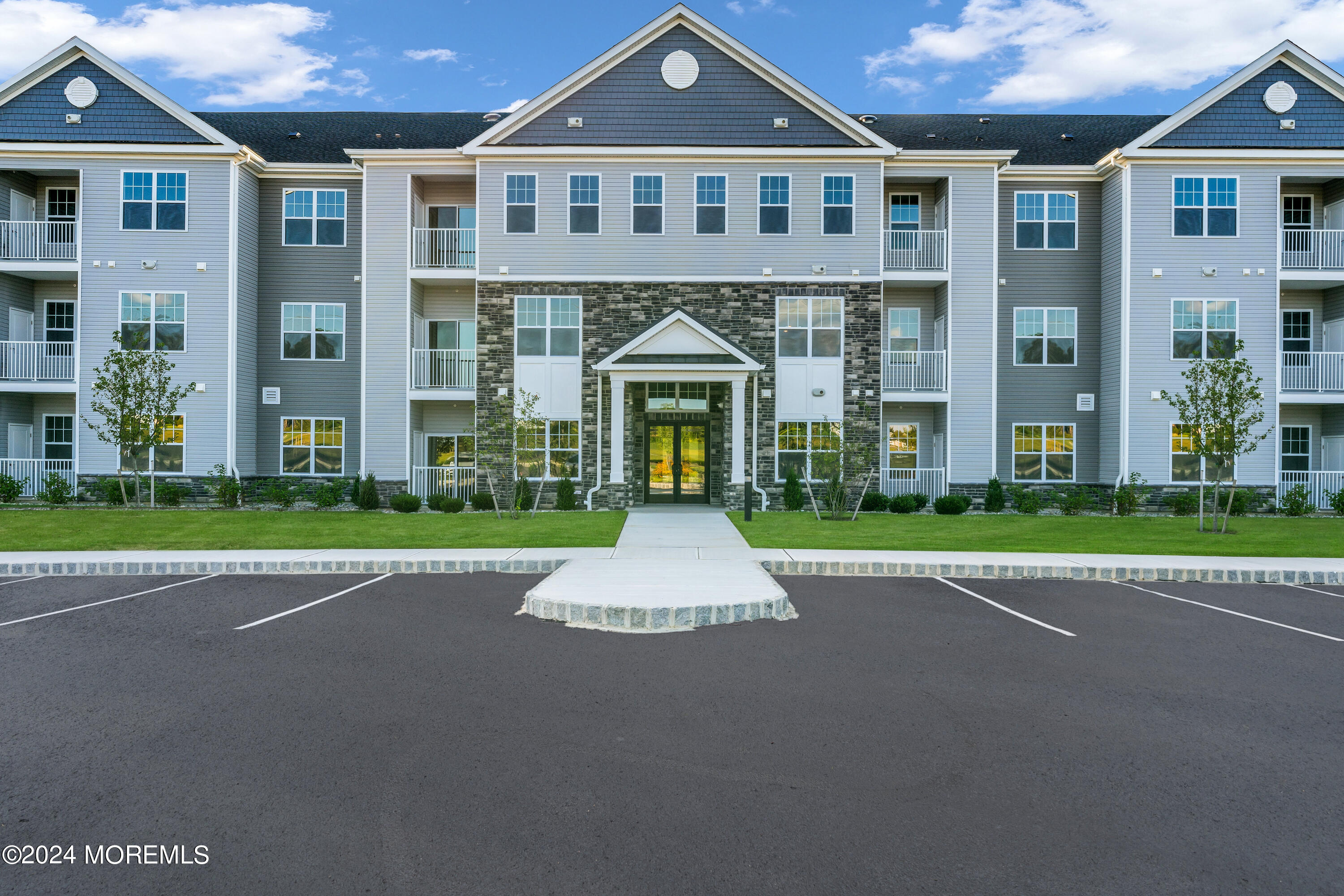 a front view of a residential apartment building with a yard