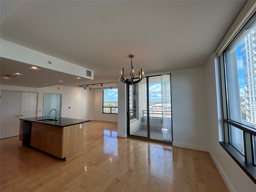 a view of a kitchen with granite countertop a refrigerator and wooden floor