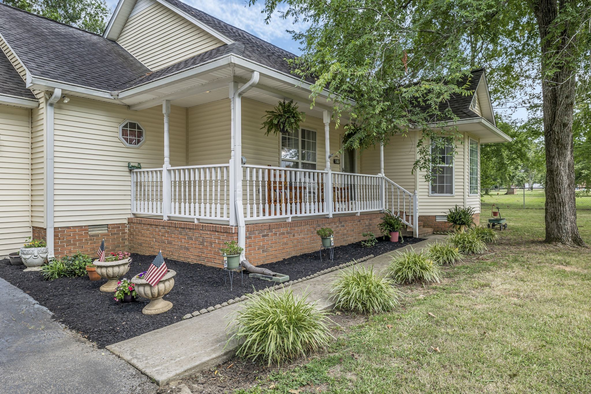 a view of a house with a yard and floor to ceiling window and a potted plant