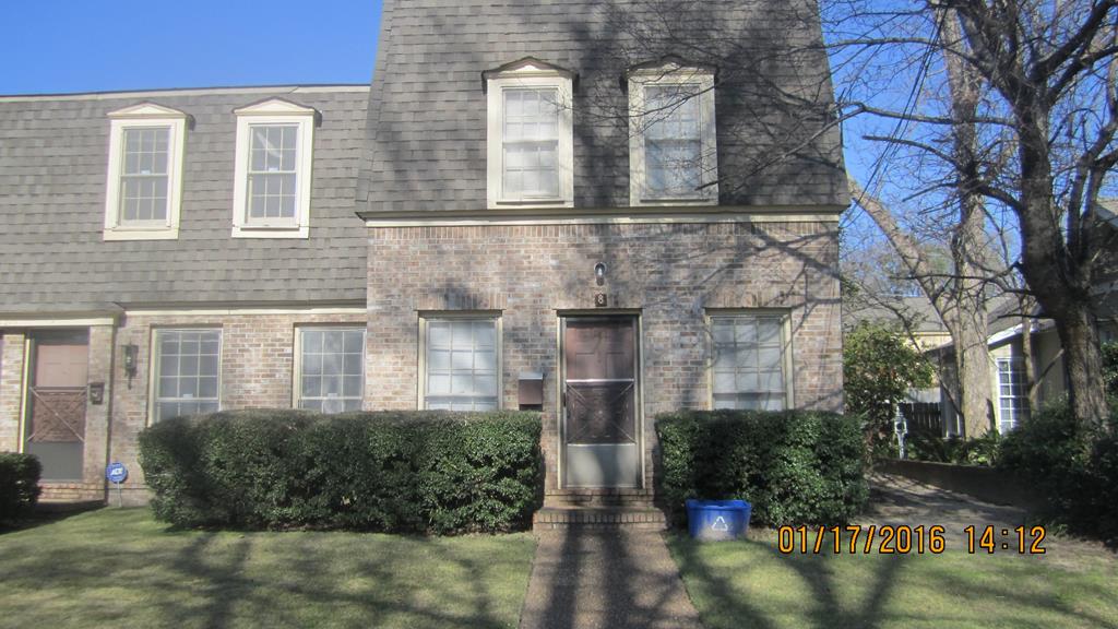 front view of a brick house with a yard