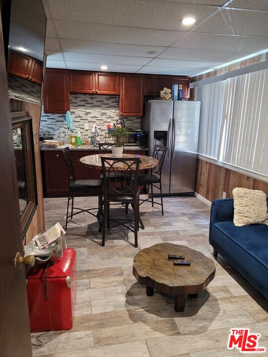 a living room with stainless steel appliances kitchen island granite countertop furniture and a large window