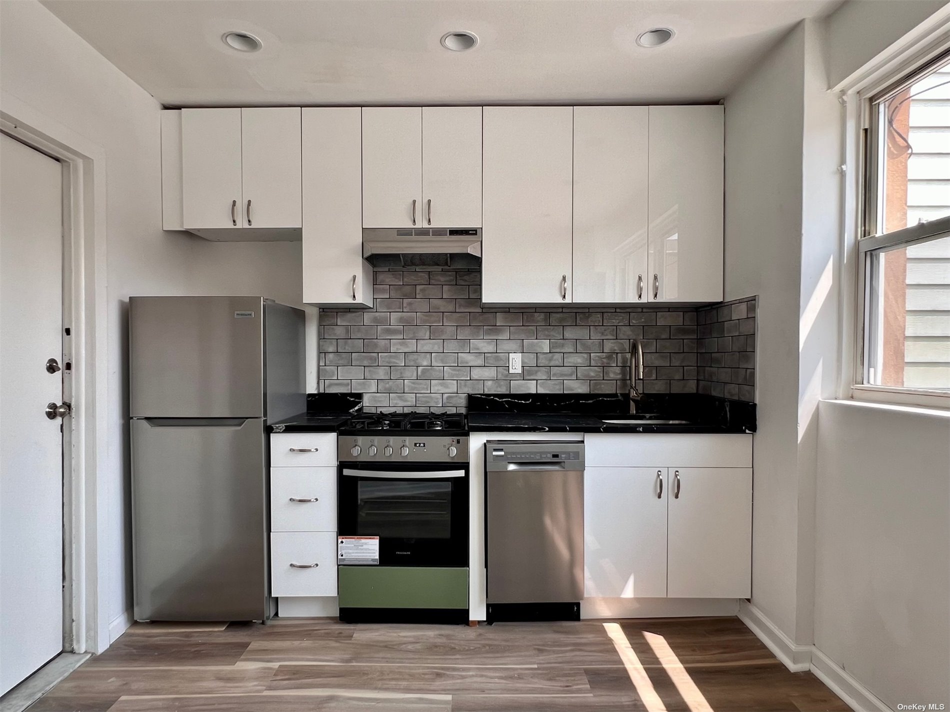 a kitchen with cabinets appliances and a window