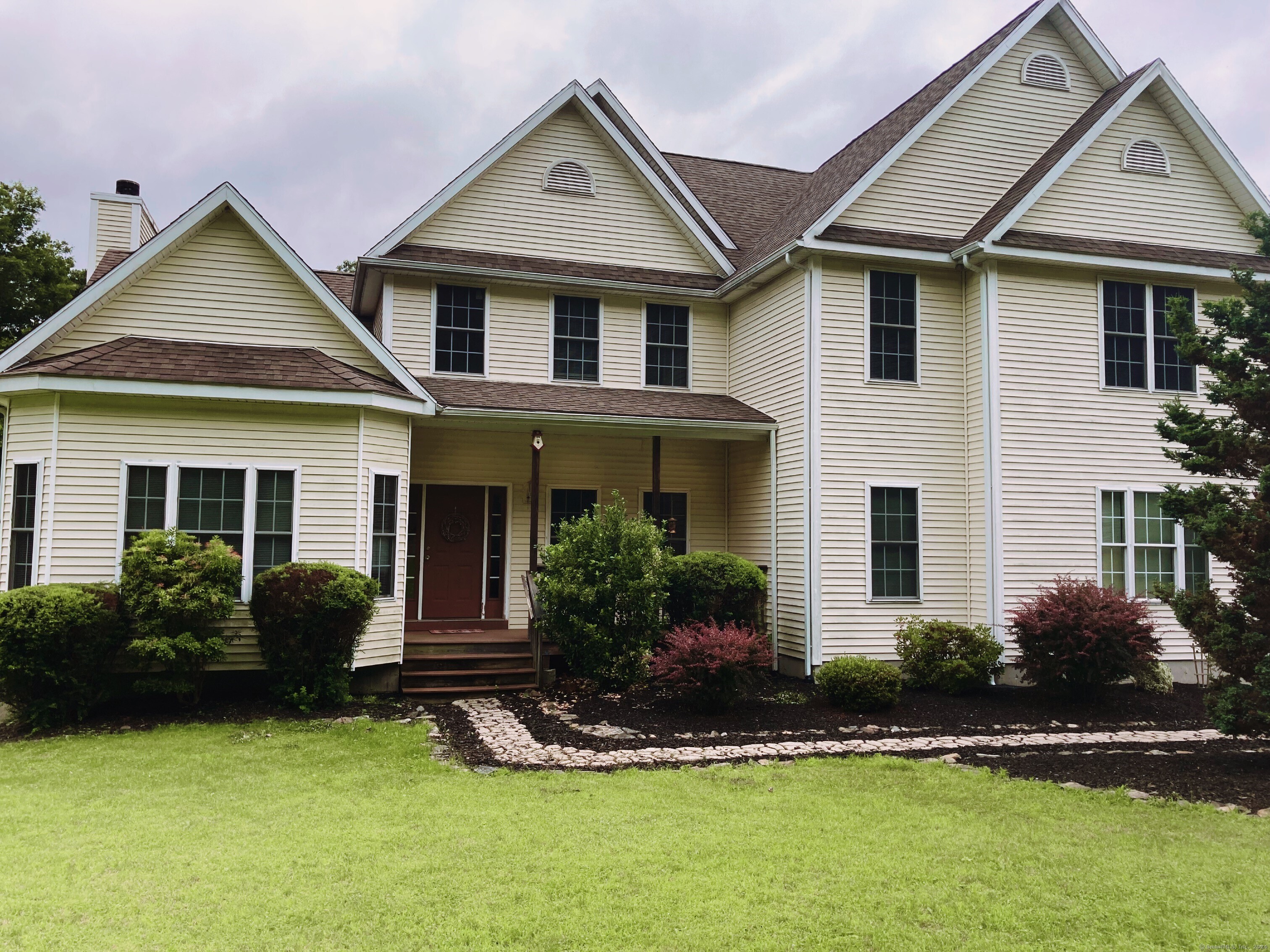 a front view of a house with a yard and outdoor seating