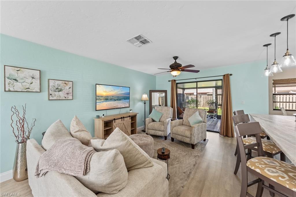 a living room with furniture a chandelier and a flat screen tv