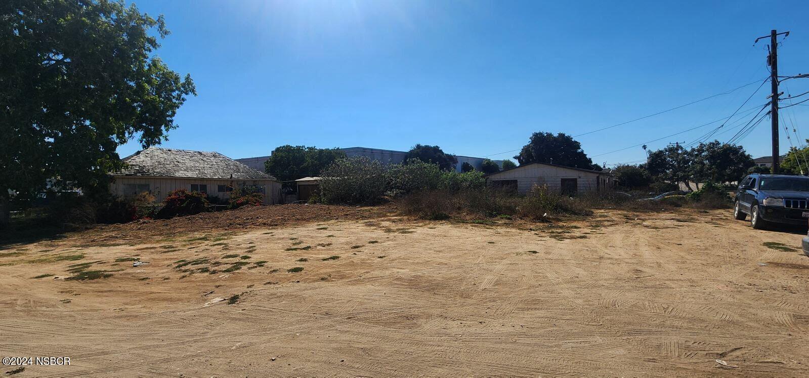 a view of dirt yard with a tree