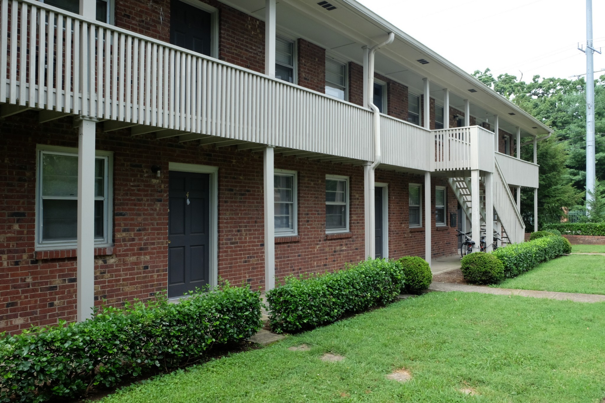 a view of a house with brick walls and a yard with plants