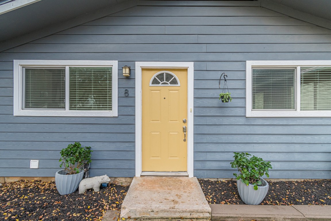 a view of a door of the house with a potted plant