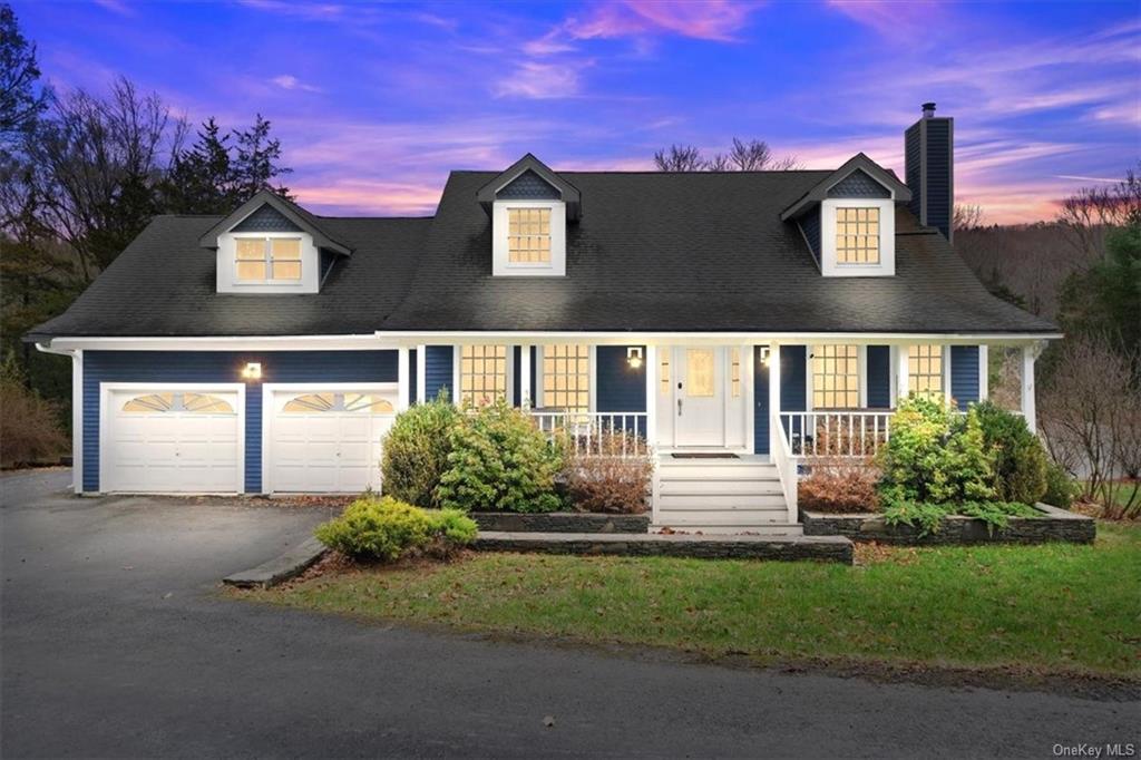 Cape cod house featuring a porch and a garage