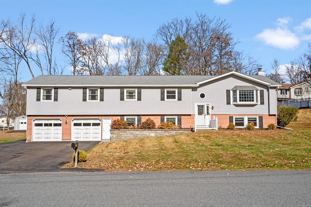 Bi-level home featuring a front yard and a garage