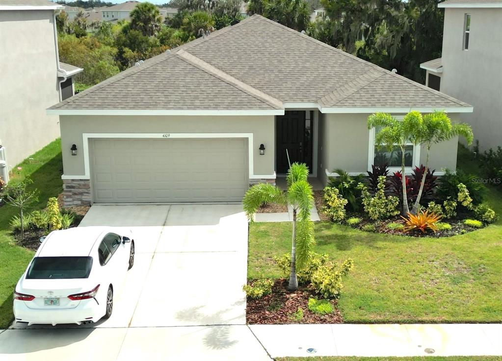 a front view of a house with a garden and plants