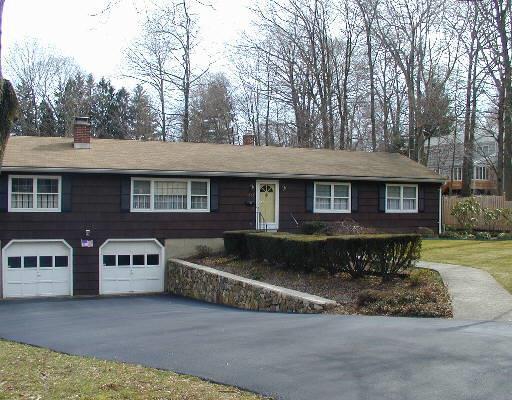 a front view of a house with a yard and tree s