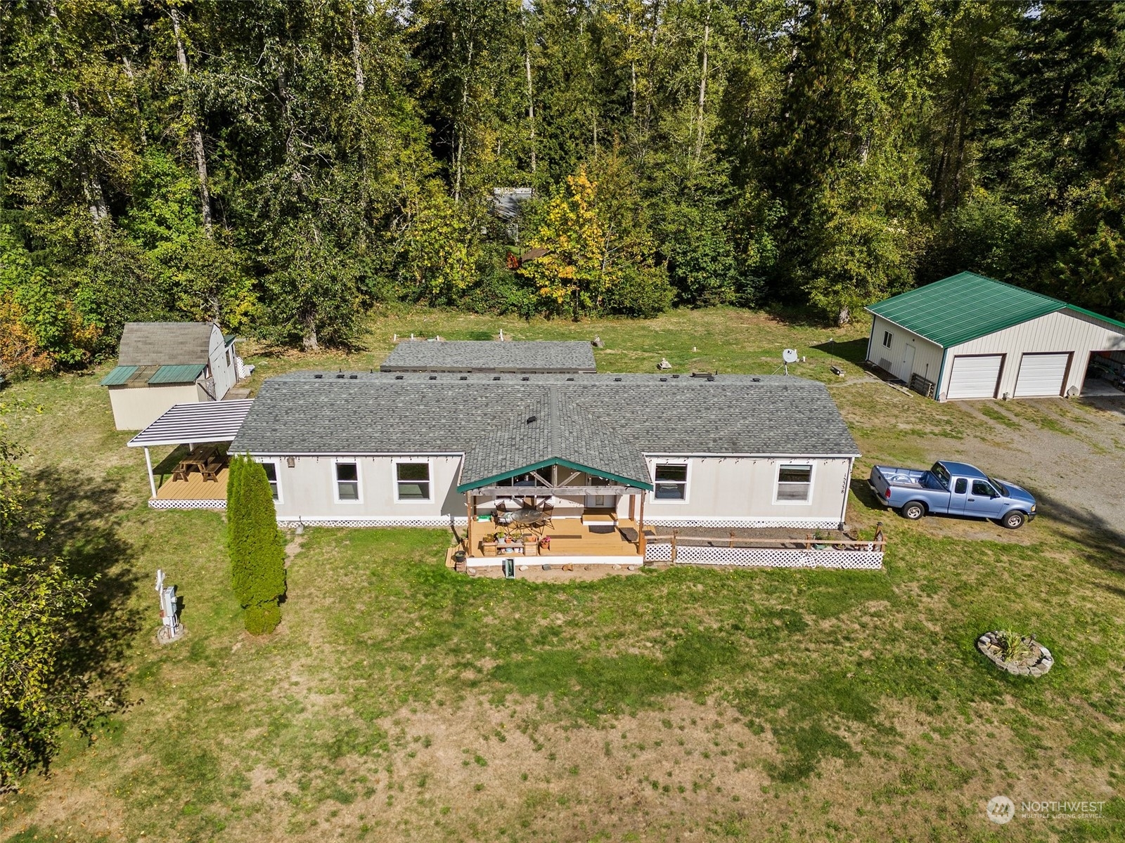 an aerial view of a house with garden space and trees all around