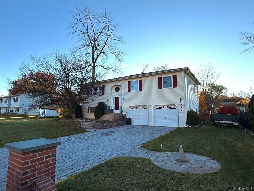 Split foyer home with a front lawn and a garage