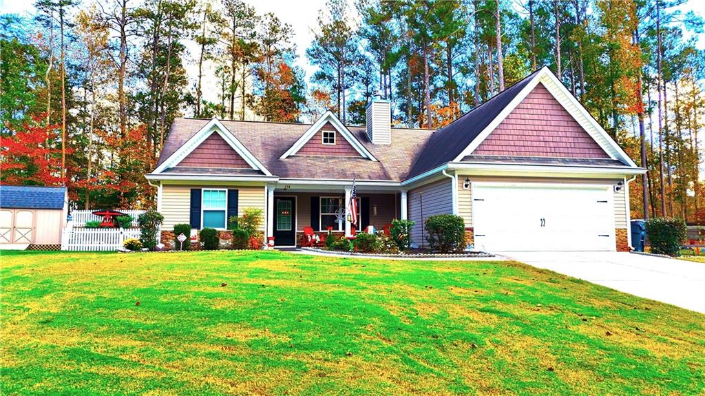 a front view of a house with a yard and trees