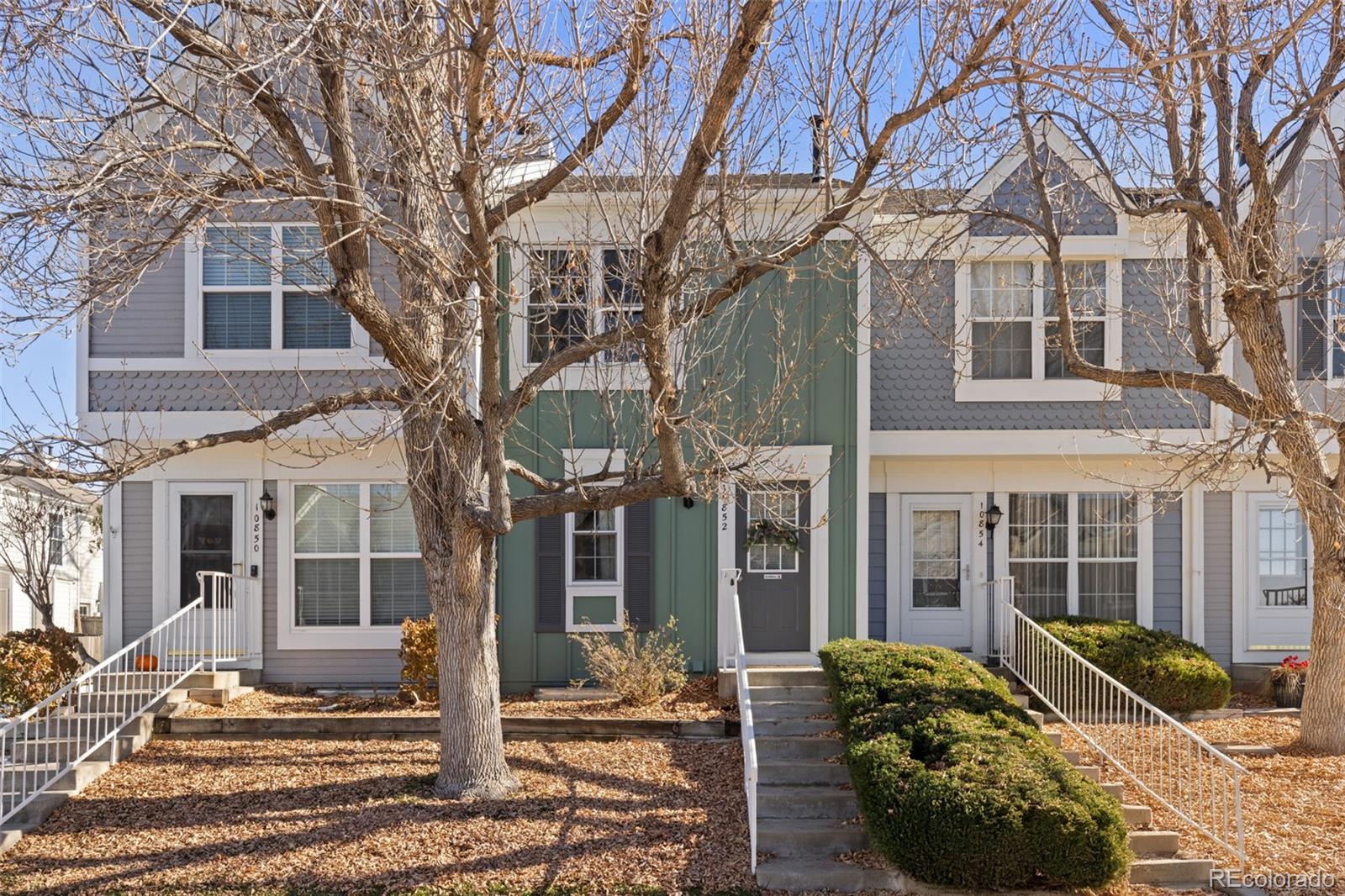 a view of a brick house with many windows next to a yard