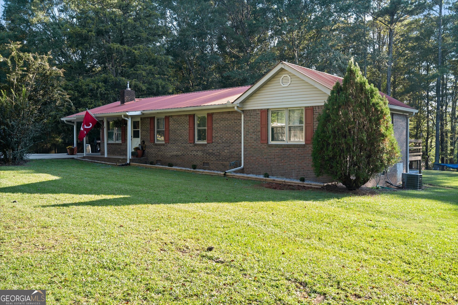 a front view of a house with a garden and trees