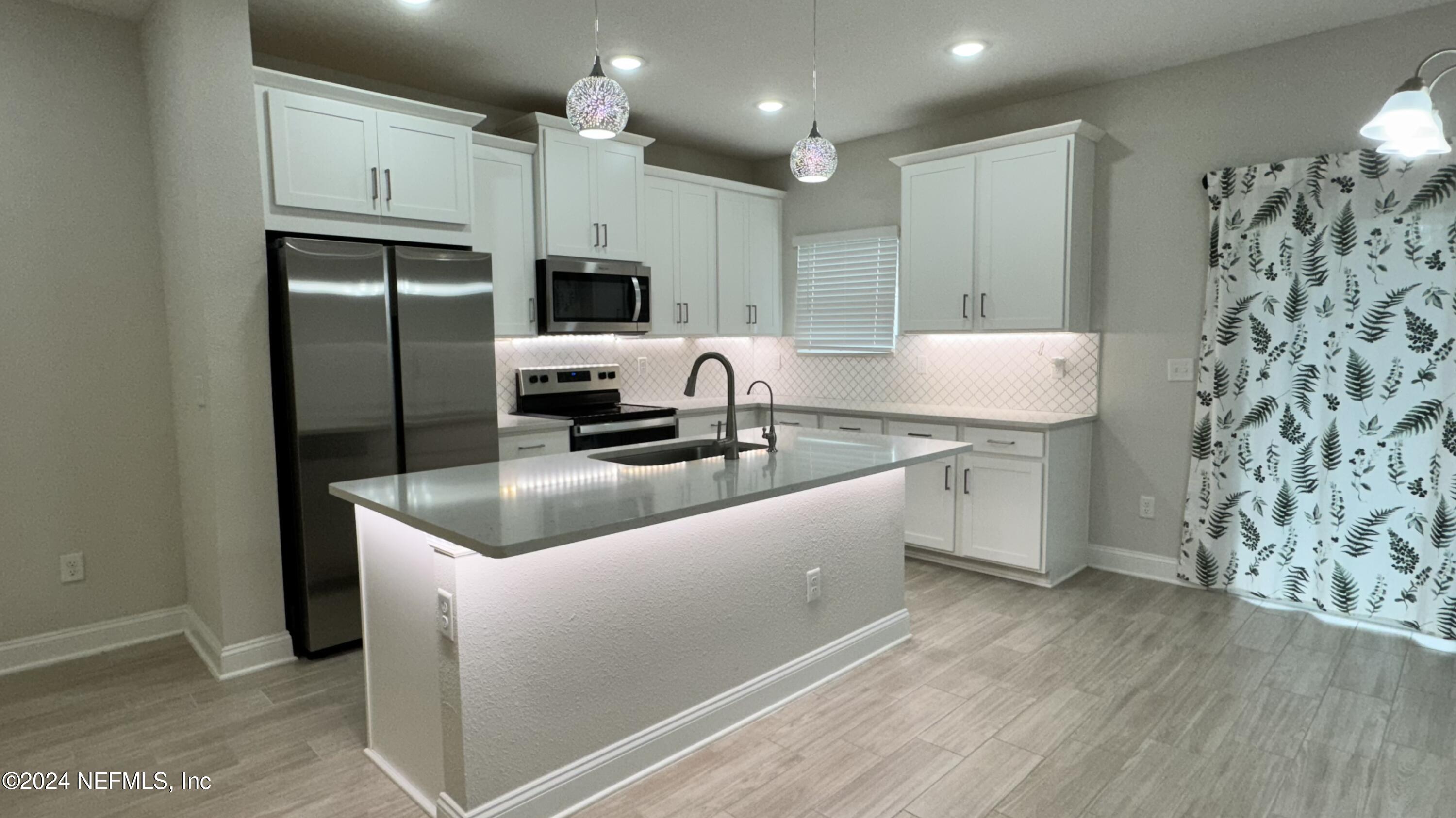 a kitchen with stainless steel appliances granite countertop a sink a refrigerator and a stove