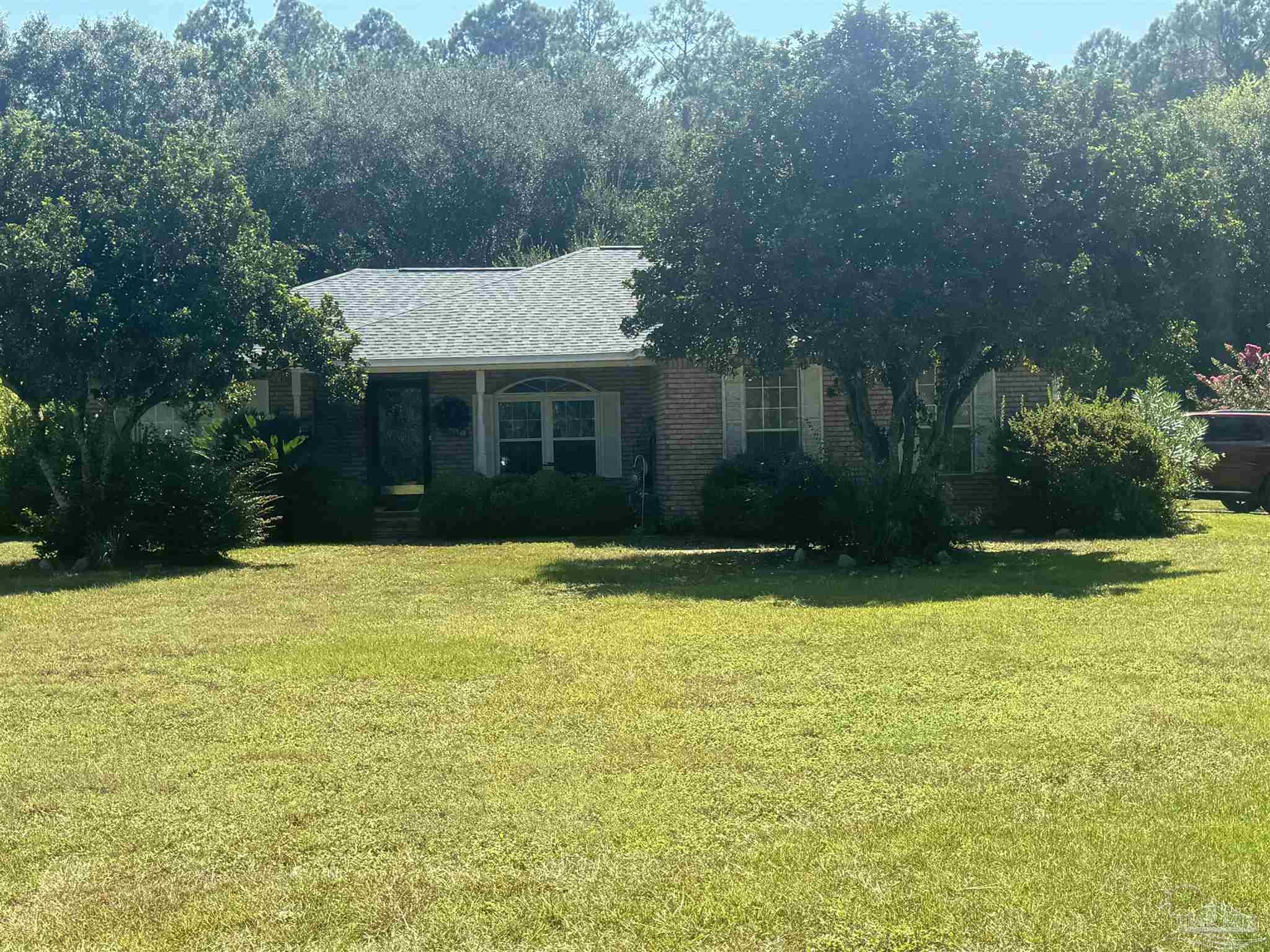 a view of a house with pool and a yard