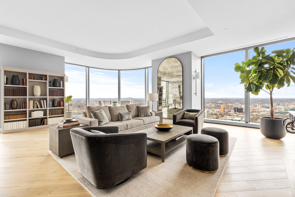 a living room with furniture potted plant and a large window