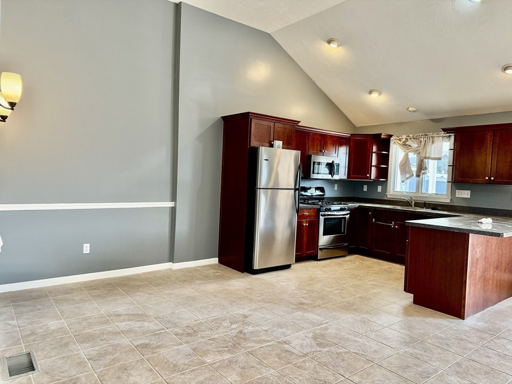 a kitchen with stainless steel appliances granite countertop a refrigerator and a wooden cabinets