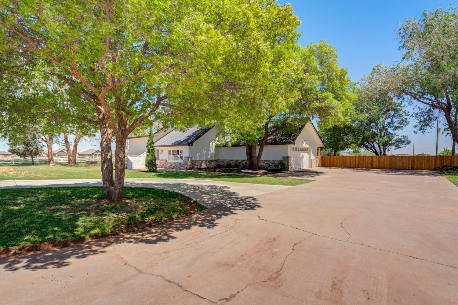 a view of a house with large trees and a big yard