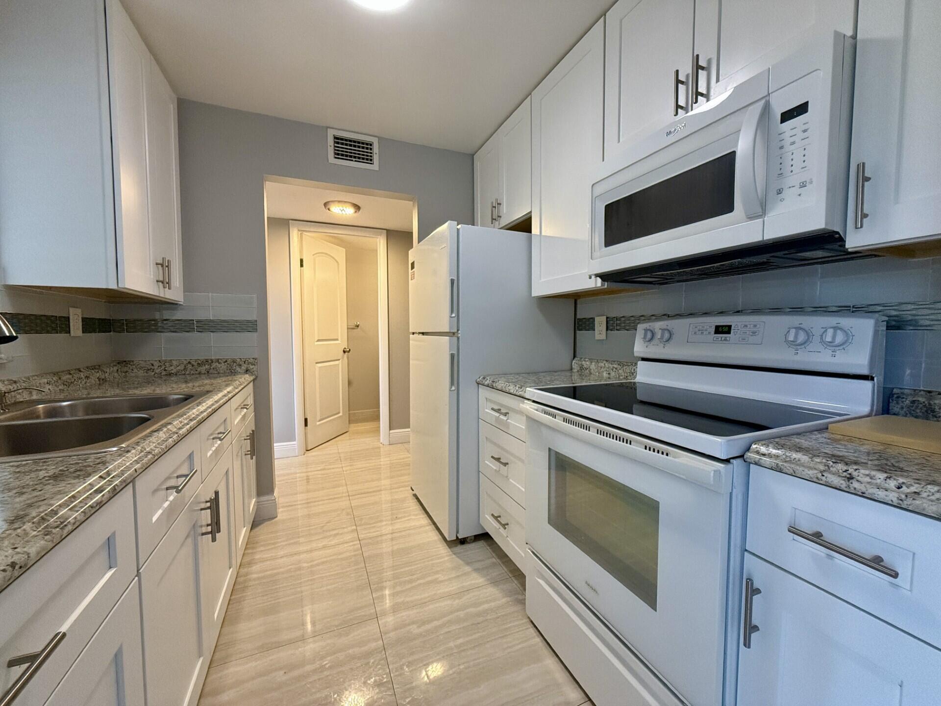 a kitchen with stainless steel appliances granite countertop a stove and a microwave