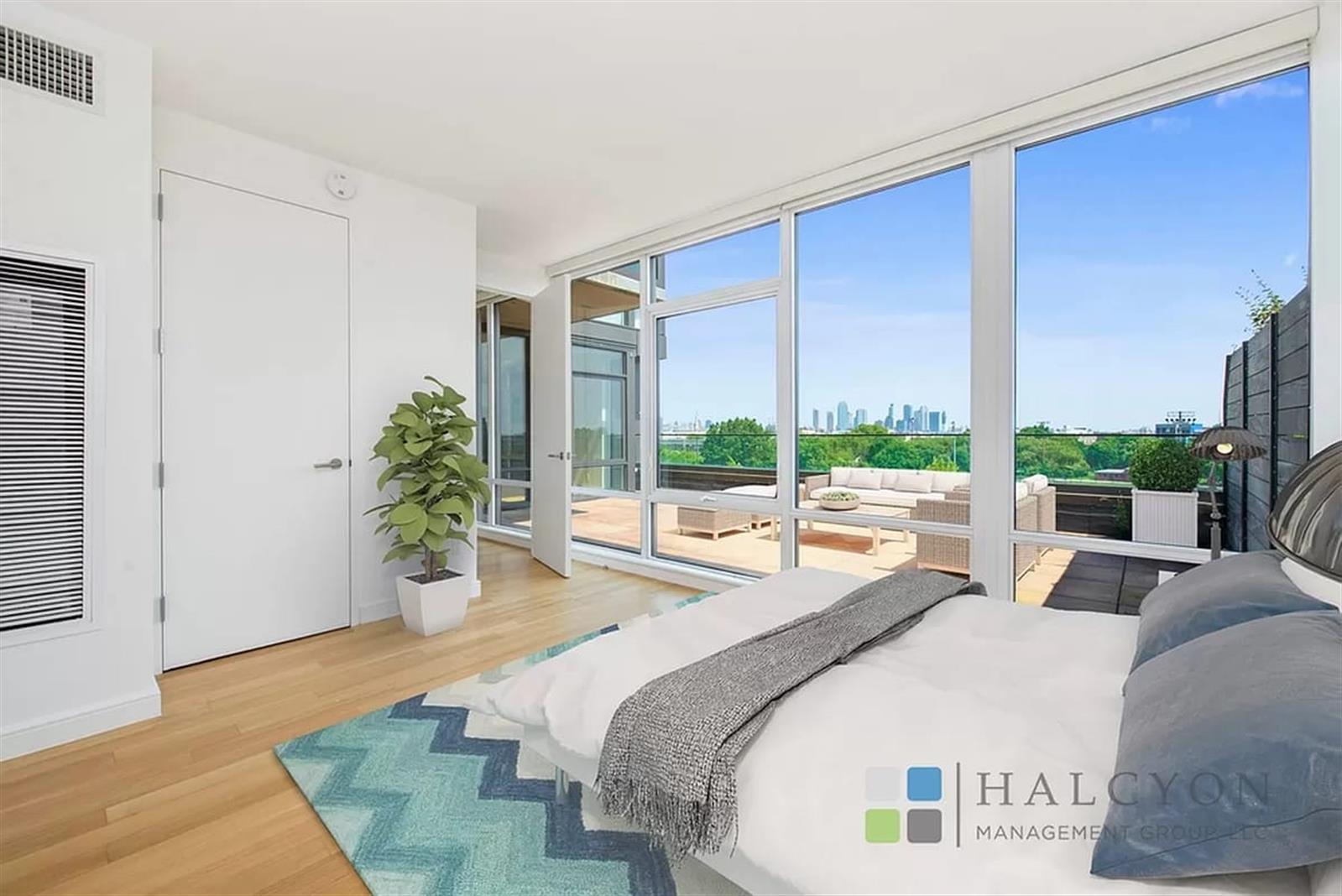 a spacious bedroom with a large window and a potted plant